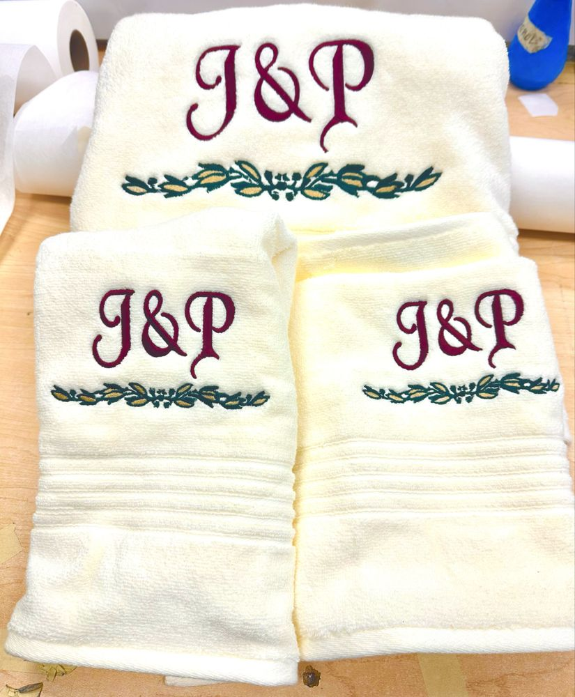 Cream bath towels monogrammed with J&P and a floral wreath